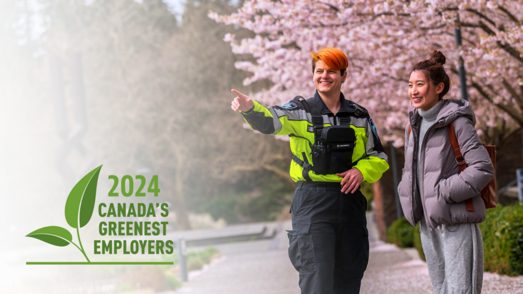Two people standing in front of cherry blossom trees, one person pointing away. The logo in the foreground reads: "2024 Canada's Greenest Employers"